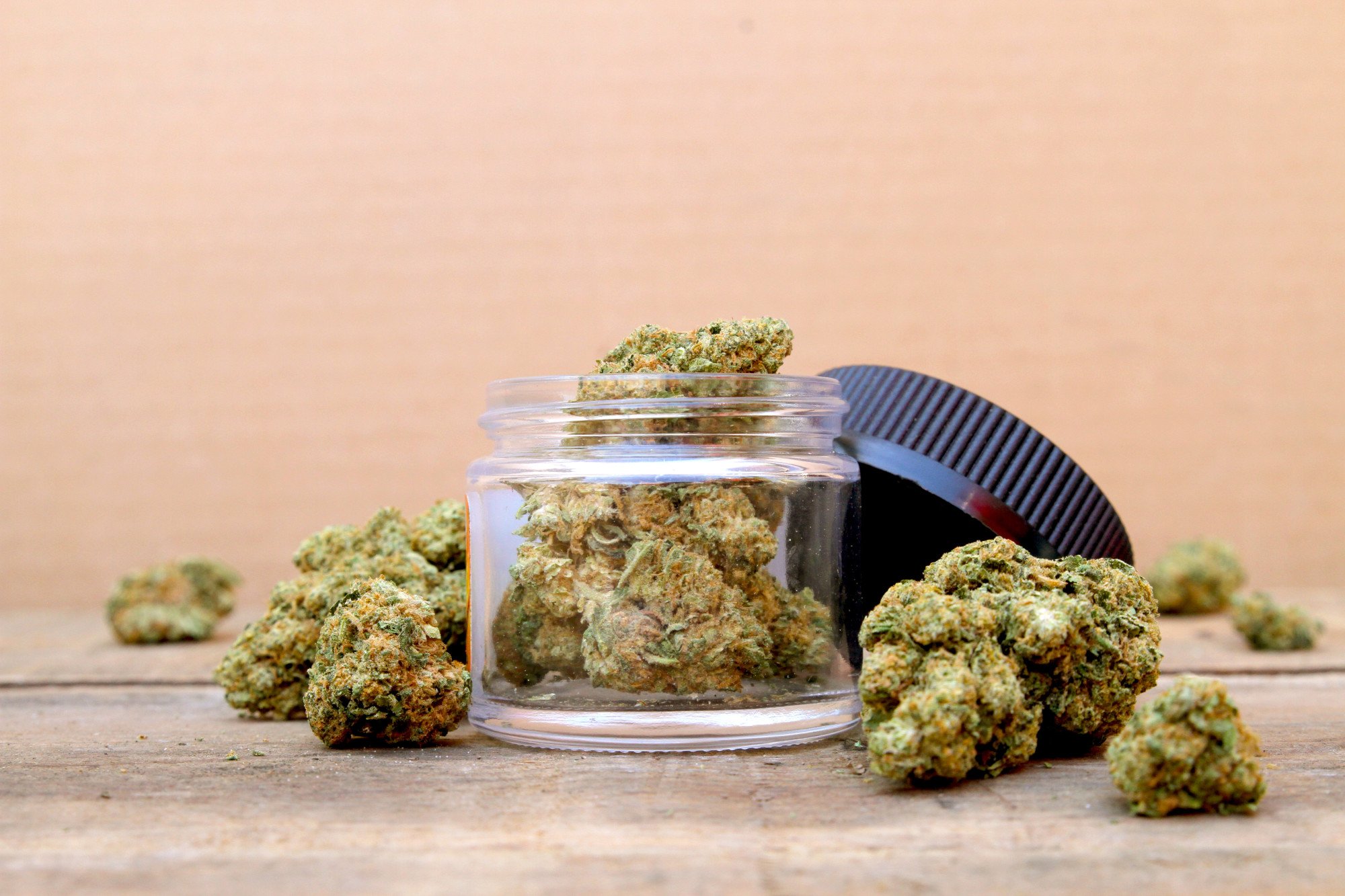 a jar of marijuana on a table to show difference of indica vs sativa vs hybrid